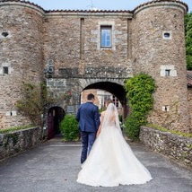 bride and groom in front of a castle in France